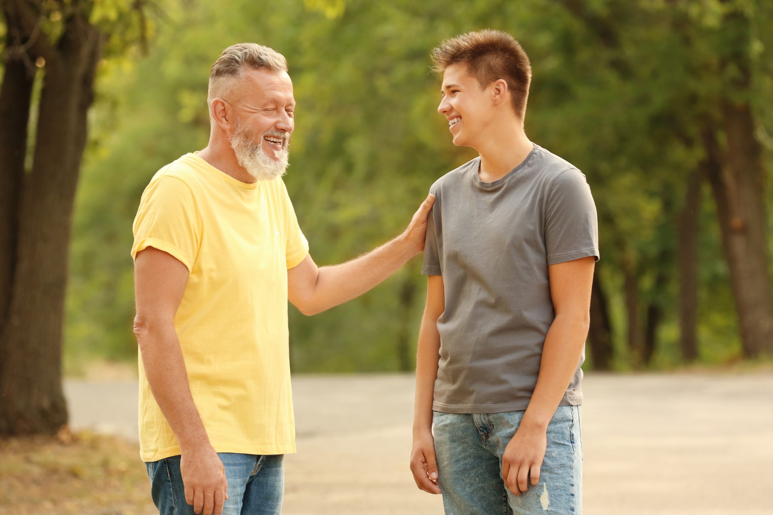 Teenager boy with grandfather in park